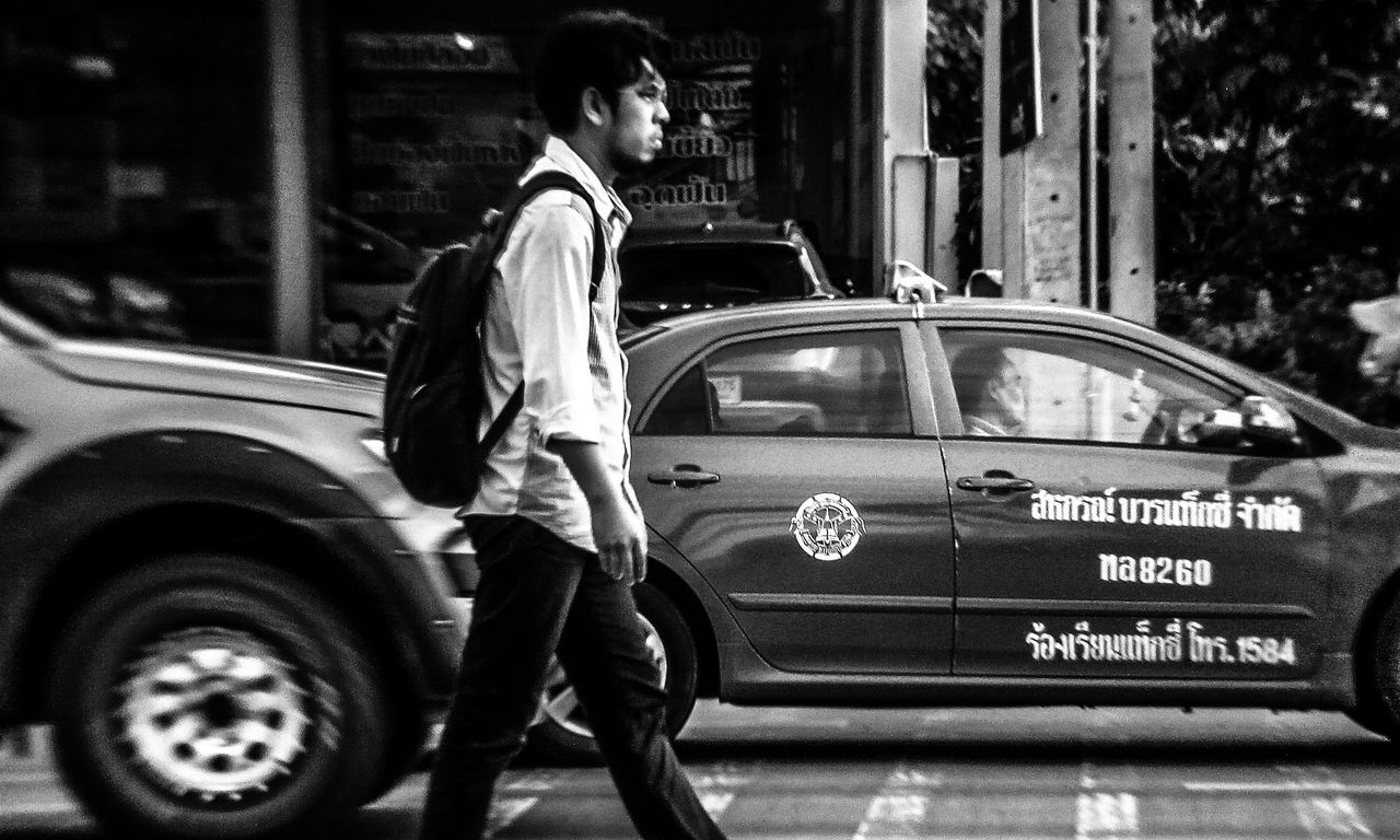 mode of transportation, motor vehicle, car, transportation, land vehicle, real people, one person, standing, full length, city, men, architecture, lifestyles, day, side view, street, casual clothing, building exterior, luxury