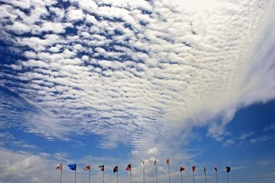 Various flags against cloudy sky