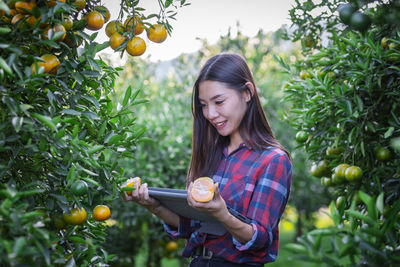 Young woman looking away while standing on plants