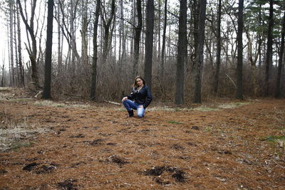 Man sitting on field in forest