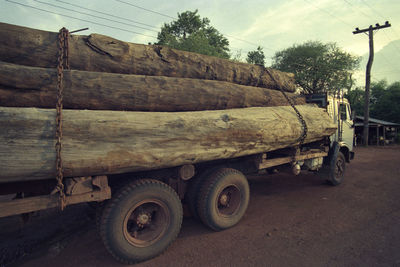 Close-up of truck on road by trees against sky