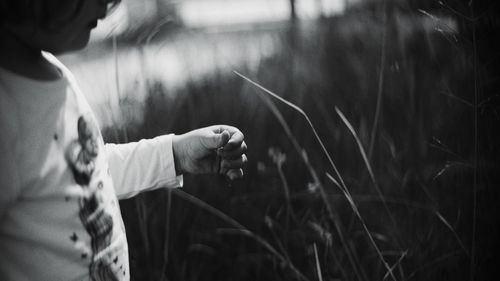 Midsection of girl standing against plants