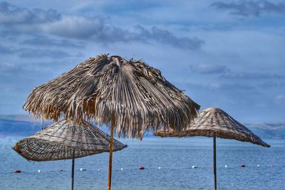 Traditional windmill on beach against sky