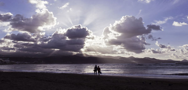 Silhouette man on beach against sky