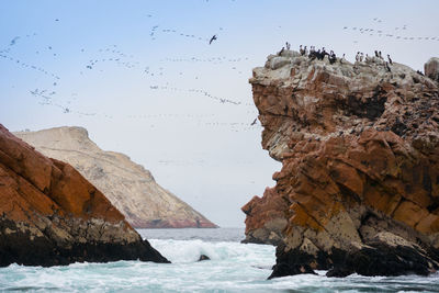 Rock formations in sea against sky