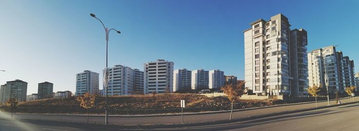 Street by buildings against sky in city