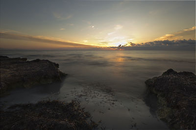 Scenic view of beach against sky during sunset