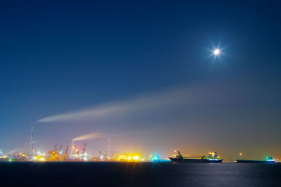 Illuminated commercial dock against sky at night