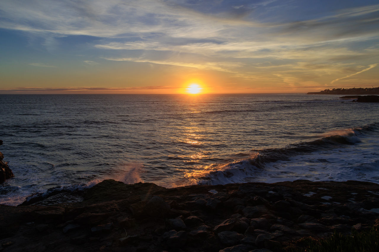 sky, sea, water, sunset, beauty in nature, land, beach, scenics - nature, horizon, cloud, ocean, nature, horizon over water, coast, shore, sun, tranquility, dawn, wave, evening, tranquil scene, seascape, sunlight, idyllic, wind wave, dramatic sky, body of water, environment, motion, afterglow, orange color, travel destinations, travel, outdoors, rock, vacation, trip, coastline, landscape, holiday, no people, urban skyline, sports, tourism, non-urban scene, water sports, reflection