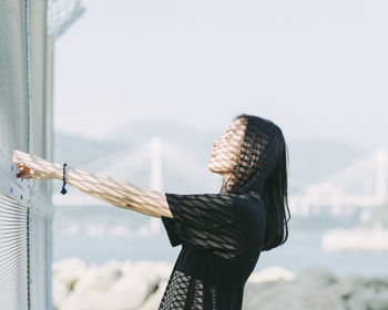 Close-up of woman by sea against sky