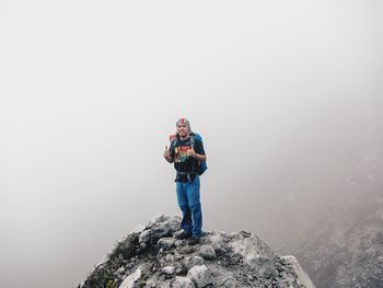 Portrait of man gesturing while standing on rock