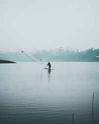 Man surfing in lake against sky