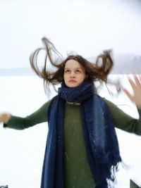 Close-up of cute girl in snow against sky