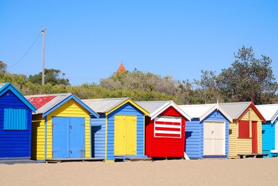 Beach huts against clear blue sky