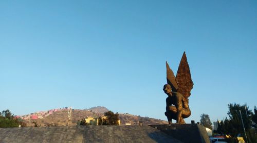 Low angle view of statue against clear blue sky
