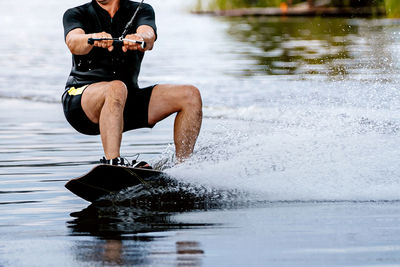 Shirtless man swimming in lake