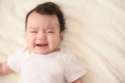 Top view of cute little asian baby crying with copy space