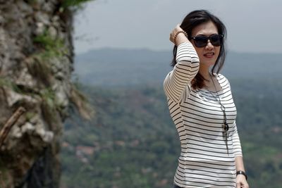 Portrait of woman wearing sunglasses against mountains