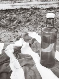 Close-up of hand holding bottle at beach