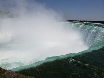 Scenic view of waterfall against sky