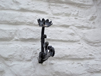 Black cast iron candle holder on a white wall