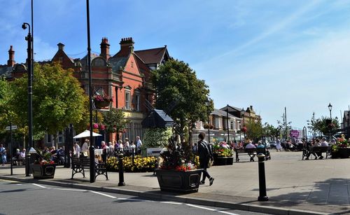 People on street against buildings in city