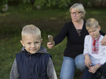 Portrait of boy with brother and grandmother at park