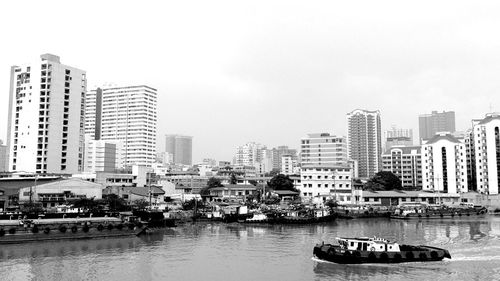 Boats in river with buildings in background