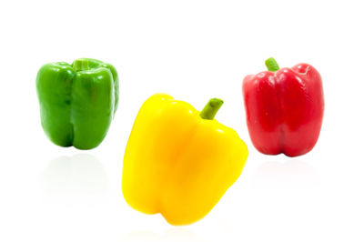 Close-up of multi colored bell peppers against white background