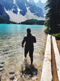 Rear view of man on lake against mountains