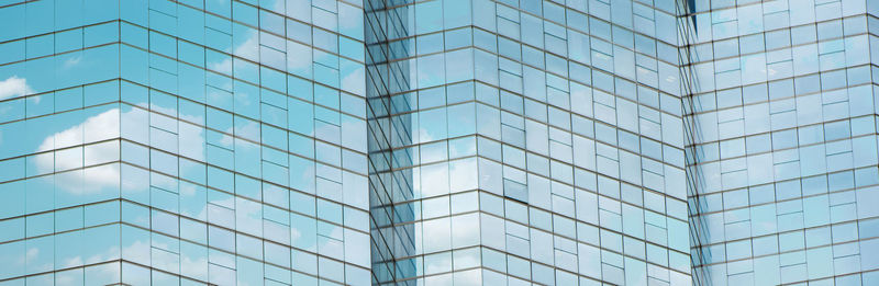 Cloud reflected in windows of modern office building.