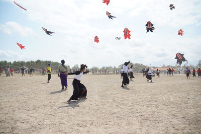 People enjoying kite festival against sky