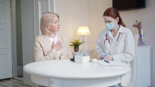 Doctor wearing mask examining patient