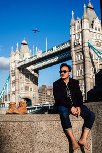 Man sitting against tower bridge