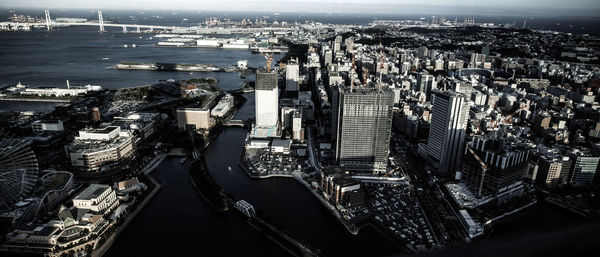 High angle view of illuminated city by sea against buildings