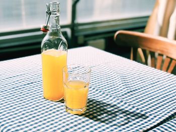 Orange juice in bottle and glass on table