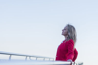 Young woman standing against clear sky