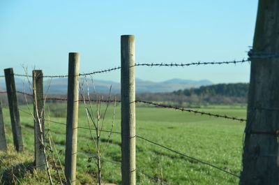 Fence on field against clear sky