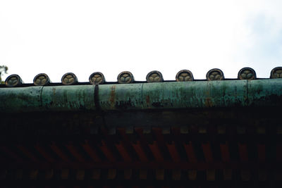 Low angle view of rusty metallic structure against sky