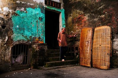 Man walking down steps at abandoned building