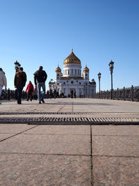 Tourists in front of temple against clear sky