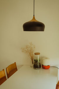Electric lamp on table against wall at home