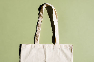 Reusable cotton shopping bag on green and beige background. zero waste concept. no plastic