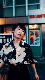 Young woman looking away while standing at store