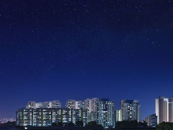 Illuminated cityscape against blue sky