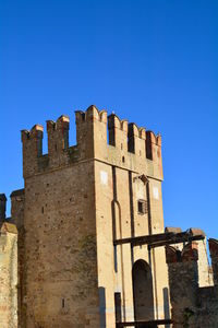 Low angle view of historic building against blue sky