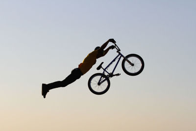 Man riding bicycle against sky