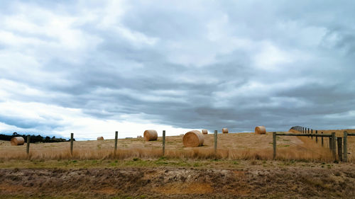 View of field against cloudy sky