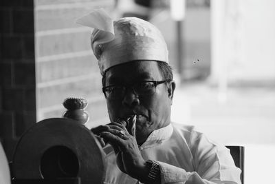 Close-up of man playing musical instrument while sitting outdoors