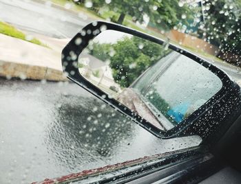 Reflection of car on wet window during rainy season